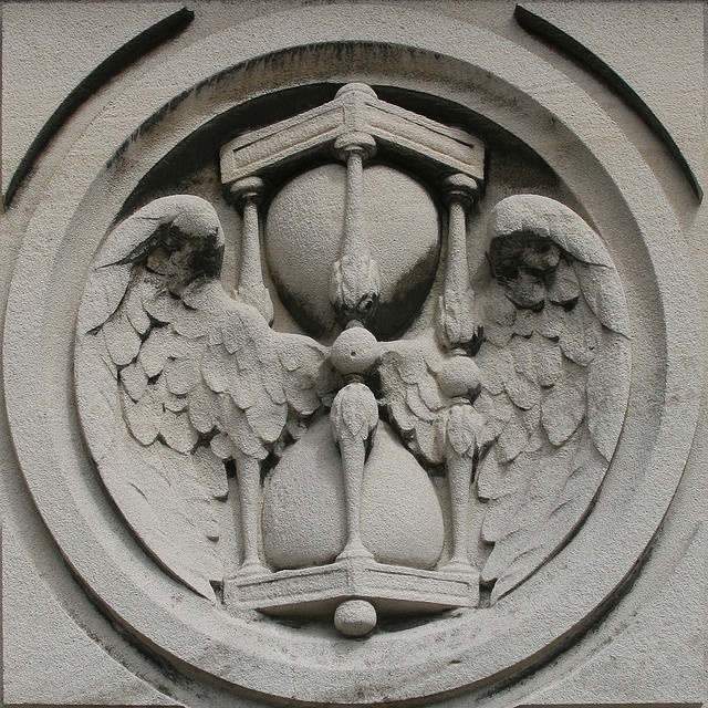 The horizontal plane of an hourglass symbol between wings